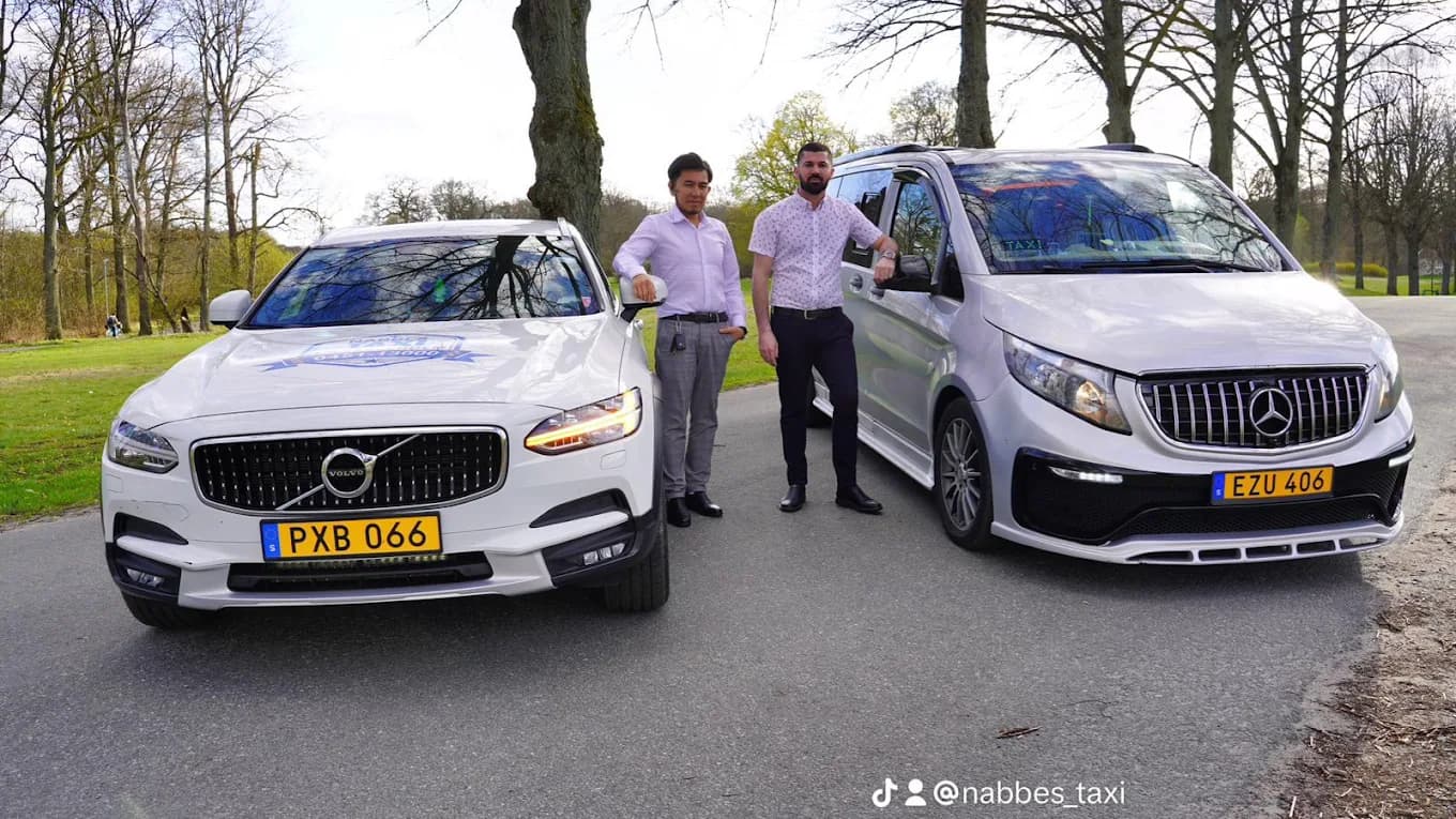 Två förare från Nabbes Taxi står mellan sina bilar